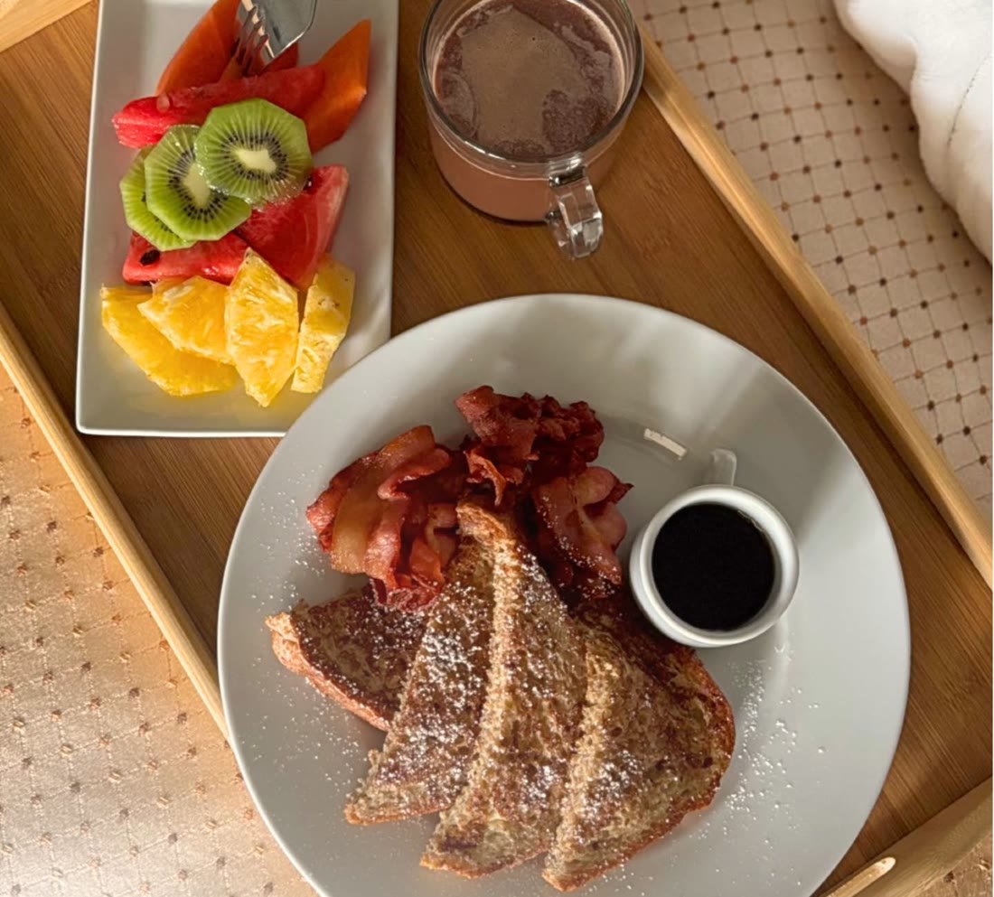 French toast, bacon and fresh fruit on a breakfast tray