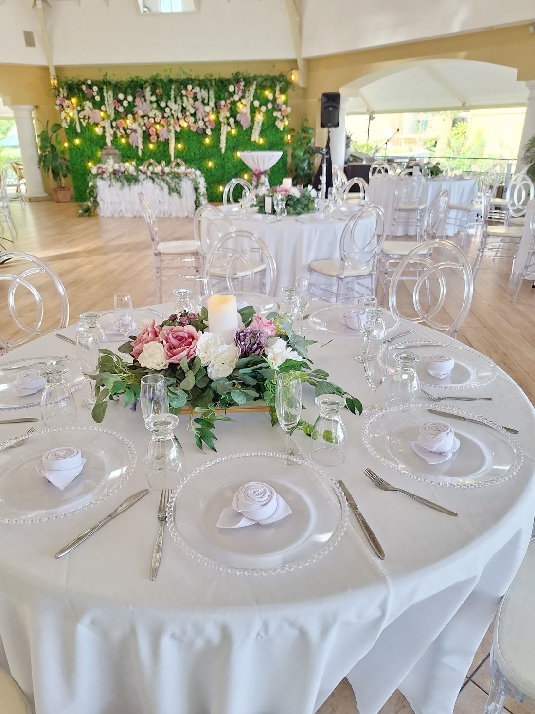 Round banquet table with glass chargers and a floral centrepiece